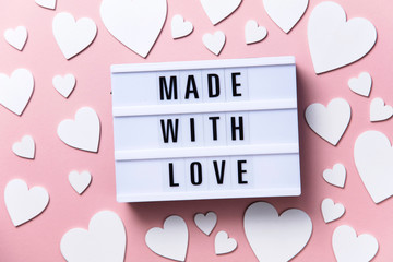 Made with love lightbox message with white hearts on a pink background