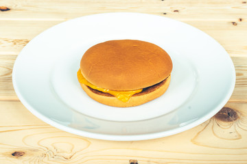 plain cheese burger on white plate and wooden table