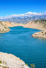 Fototapeta premium Mountain landscape with a concrete bridge across the bay.