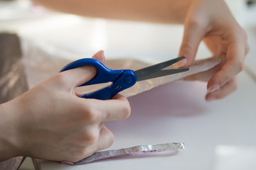 woman hands cutting paper material with scissors
