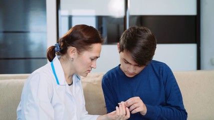 Obraz premium Woman shows a young man a hearing aid.