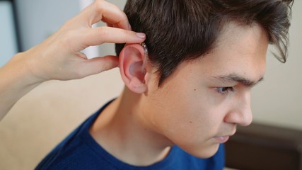 Fototapeta premium A young guy wearing a hearing aid.