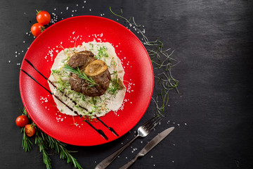 Grilled meat steak on pita leaf in a red plate