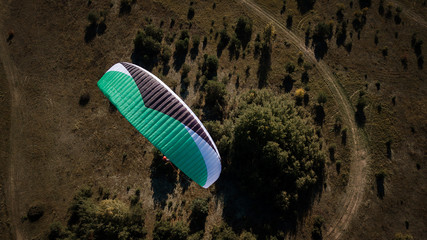 Paraglider flies over fields. High altitude. The athlete turns the thermal current. Rise up....