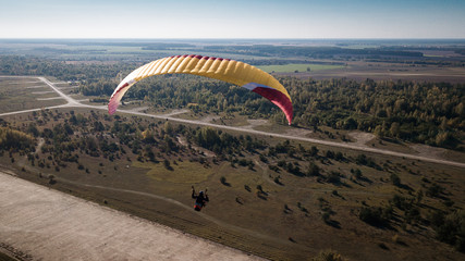 Paraglider flies over fields. High altitude. The athlete turns the thermal current. Rise up....