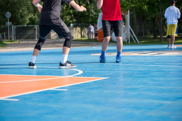 Abstract, blurry background of boys playing basketball in outdoor basketball court in park  