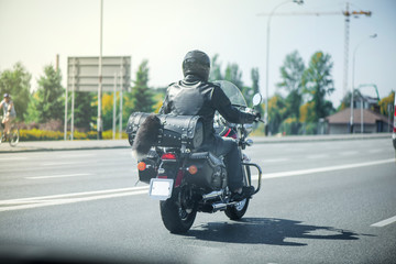 Vintage look abstract shot of black biker with motorcycle driving on highway. Road trip around Europe. Lonely traveler
