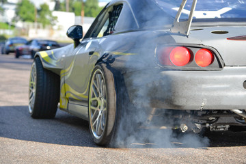 Drift cars standing at the start line, waiting for race to begin. Rally car warming up the tires,...