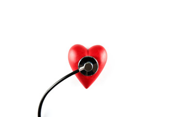 Heart disease awareness and prevention concept. Stethoscope and red heart on white isolated background with a lot of copy space for text. Close up, top view. Medical equipment for cardiologist.