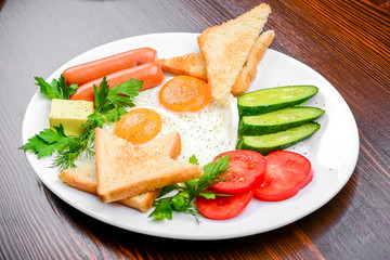 fried eggs with bacon, sausages and toasts