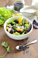 Healthy salad with chickpeas, beets, greens mix and yogurt-garlic sauce, vertical