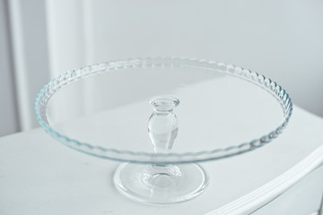 Glass cake stand on white table isolated on white background