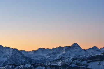 Colorful morning mood just before sunrise. View to the Allgaeu Alps with Widderstein mountain at a cold winter day. Copy space