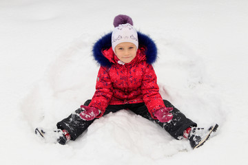 Fototapeta na wymiar a girl plays in the snow in winter