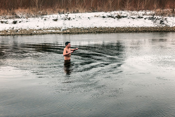 young man in cold winter river