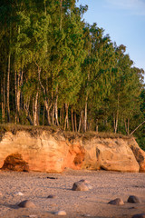 Obraz premium Veczemju cliffs on Baltic sea. Beautiful sea shore with limestone and sand caves and cliffs on each side next to forest. Calm, relaxing, meditation nature. Concept of romantic evening and holidays