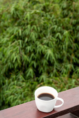White cup of hot coffee on nature background. Bali island. Volcano Batur.