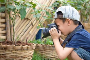 Hand boy holding the camera Taking pictures in park.
