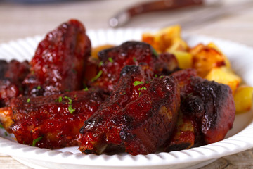 Grilled pork spare ribs with fries. Roasted sliced barbecue ribs