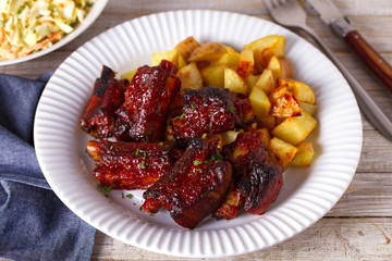 Grilled pork spare ribs with fries. Roasted sliced barbecue ribs