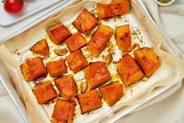 tray with roasted pieces of sweet pumpkin with honey and seasonings, top view