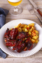 Grilled pork spare ribs with fries. Roasted sliced barbecue ribs
