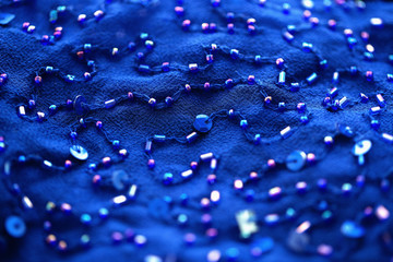 sequins and bugles on blue textile background