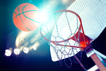 Deportes y entretenimiento. Baloncesto y deportes de equipo.Canasta  y pelota iluminados por los...