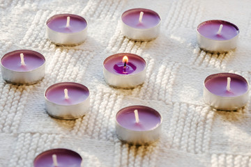 purple, aromatic candles on a white background