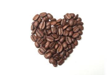 closeup of coffee beans in shaped heart on white background