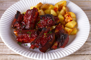 Grilled pork spare ribs with fries. Roasted sliced barbecue ribs