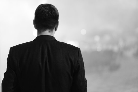 Young Man In Jacket Photographed From The Behind. Black&white Photo.