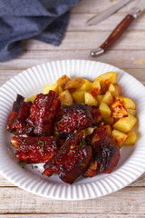 Grilled pork spare ribs with fries. Roasted sliced barbecue ribs