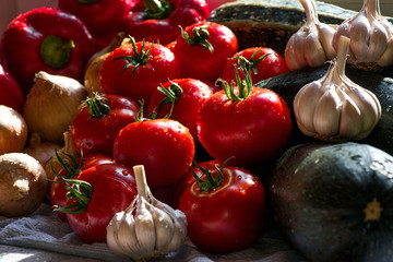 Ripe fresh harvested vegetables on table. Onions, tomatoes, garlic, pepper, zucchini in kitchen. Making delicious vegetarian meal or canning veggies for winter in jars. Concept of healthy eating