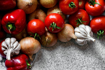 Ripe fresh harvested vegetables on table. Onions, tomatoes, garlic, pepper. Making delicious vegetarian meal or canning veggies for winter in jars. Concept of healthy eating