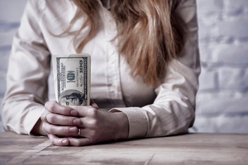 Money in hand as a symbol of success and wealth. Young successful Business Woman holding US dollars.Abundance, happiness, motivation, earning concept.