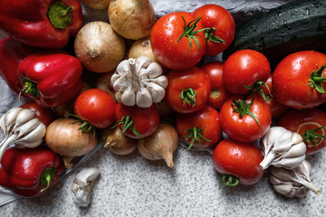 Ripe fresh harvested vegetables on table. Onions, tomatoes, garlic, pepper, zucchini in kitchen. Making delicious vegetarian meal or canning veggies for winter in jars. Concept of healthy eating