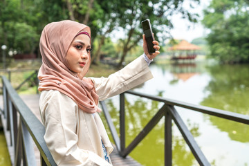 Veiled teenager at outdoor park.