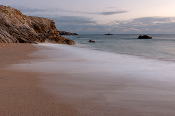 Fototapeta na wymiar French landscape - Bretagne. A beautiful beach with wild cliffs in the background at sunset.