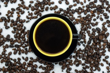 A cup of coffee on coffee beans background. Selective focus.