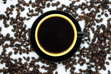 Obraz premium A cup of coffee on coffee beans background. Selective focus.