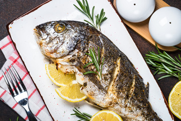 Baked dorado fish with lemon and rosemary.