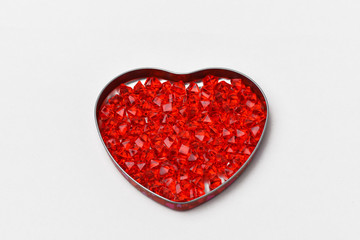 Valentines day gray background on it a box in the form of a heart, it are glass crystals of red ,...