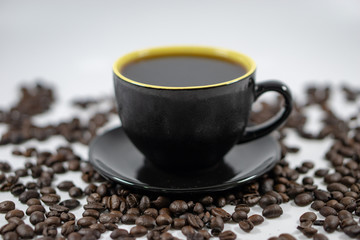 A cup of coffee on coffee beans background. Selective focus.
