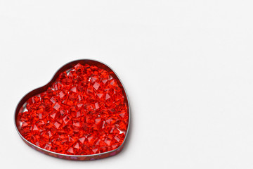 Valentines day gray background on it a box in the form of a heart, it are glass crystals of red , scarlet, ruby color . The heart is located at the bottom left, right place to sign