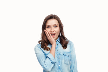 Surprised woman holding hand near cheek