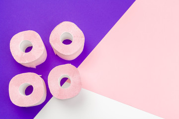 Pastel pink toilet paper on bright color block background