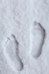 hardy person hardens his health, leaving traces of his bare feet in the snow in winter in cold weather