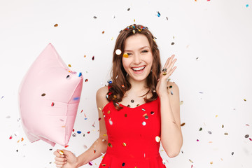 Excited woman with balloon under confetti