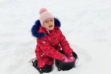 a girl plays in the snow in winter